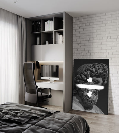 Division room mockup: monochrome bearded classical head crossed by a white division sign, shown leaning beside a bedroom desk.