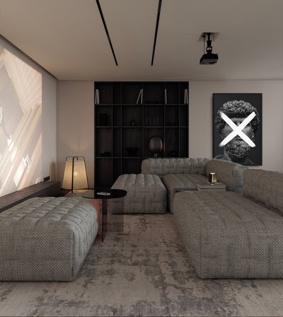 Multiplication room mockup: monochrome bearded classical head crossed by a white multiplication sign, shown behind a grey sectional sofa.