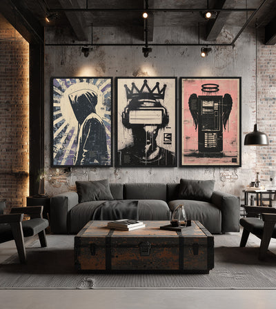 Gods We Made Collection room mockup: three stencil-style artworks showing a hooded figure, a crowned headset wearer and a winged tower, shown above a grey sofa on an exposed-brick wall.