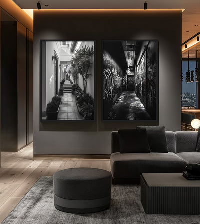 One And The Same Bundle room mockup: two monochrome passage artworks contrasting a graffiti alley and a bright plant-lined courtyard, shown behind a dark sectional sofa.