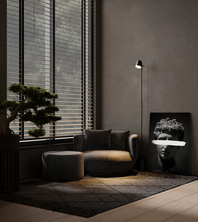 Subtraction room mockup: monochrome classical head with a white bar across the eyes, shown leaning beside a lounge chair.