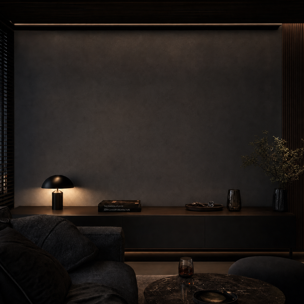 A dark, fully furnished living room with an empty wall