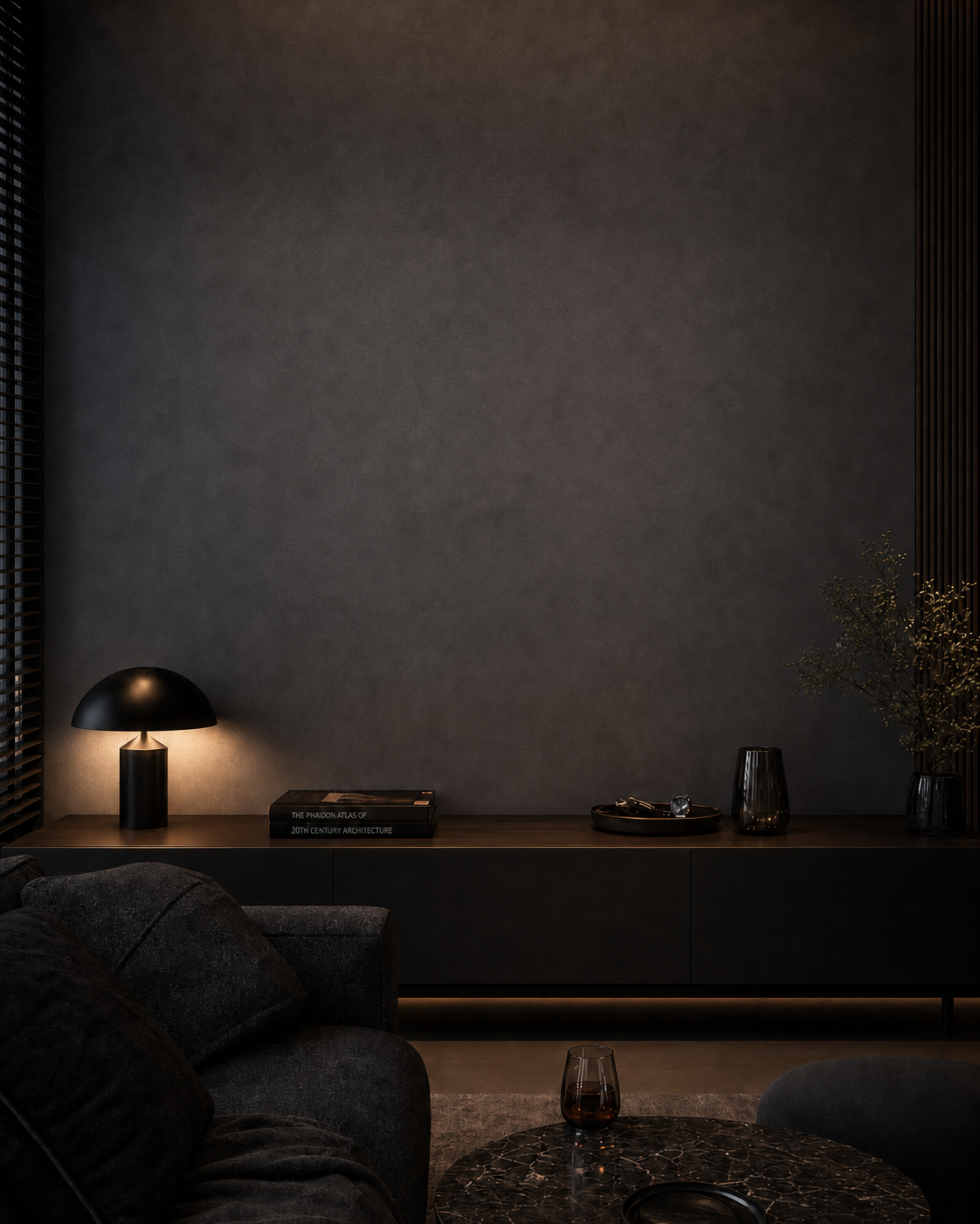 A dark, fully furnished living room with an empty wall