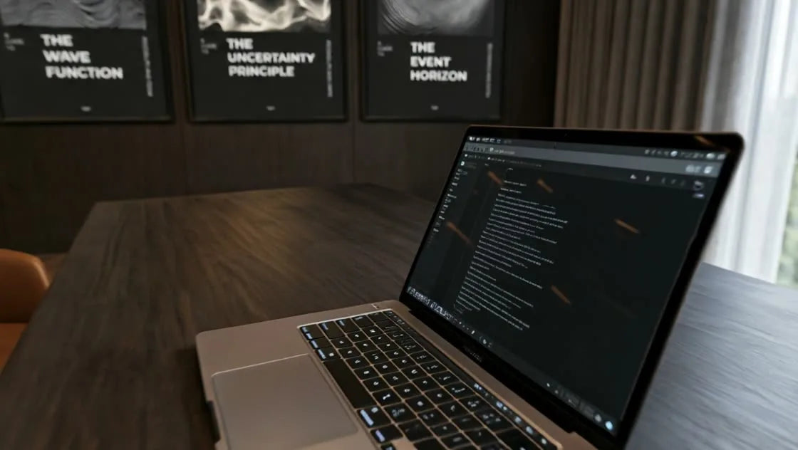 A sculptural home office with Quantum Field’s three framed artworks, a cognac chair and an open laptop